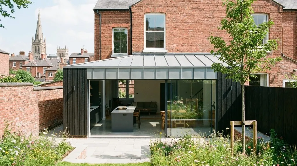 Red-brick terrace with black charred timber extension.