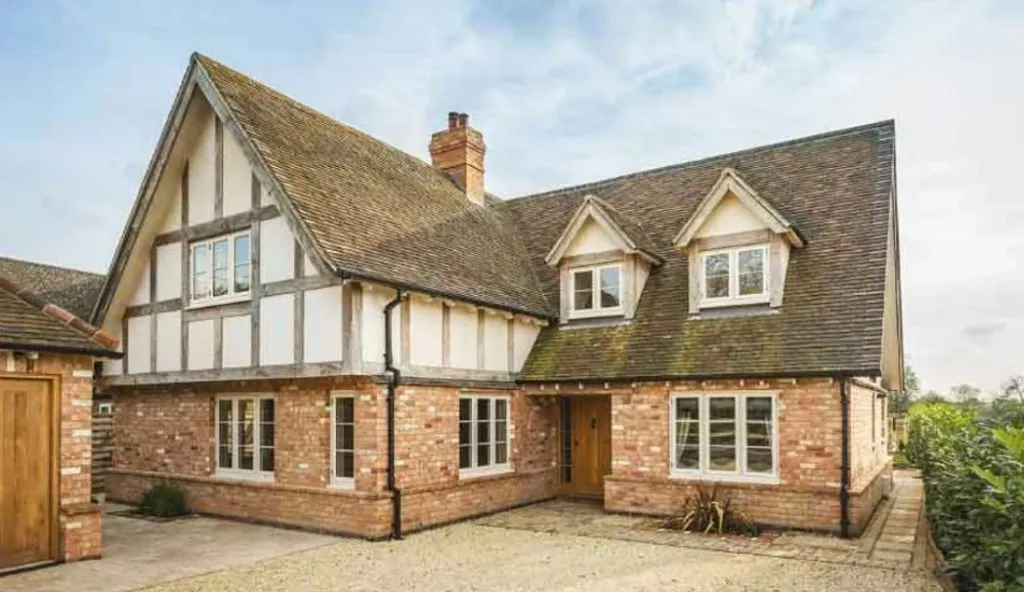 Timber-framed house with an aged tiled roof before re-roofing